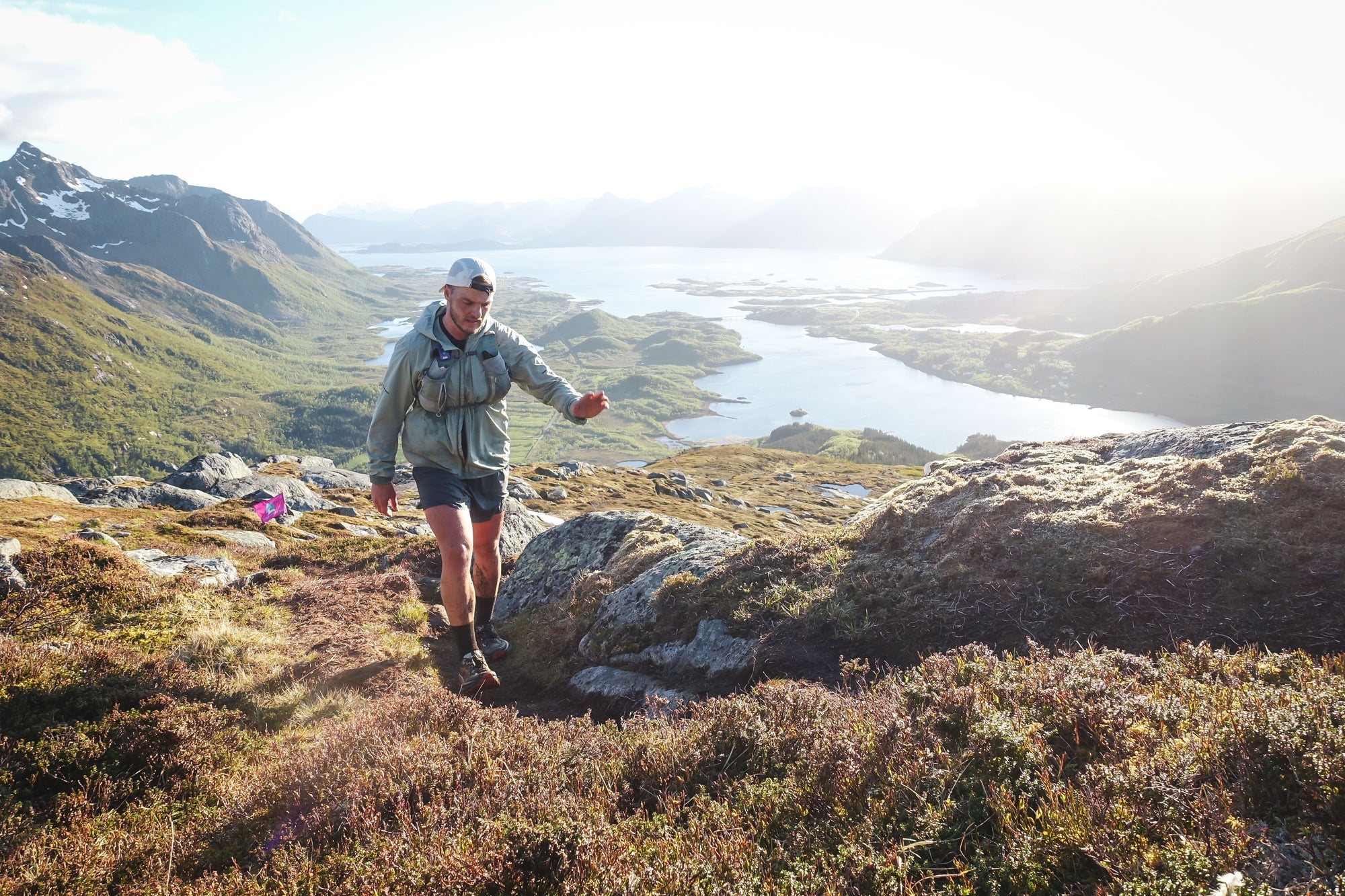 Trail running up a mountain, a fjord behind